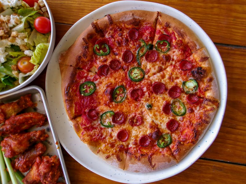 Meat Lovers round table pizza with multiple toppings
